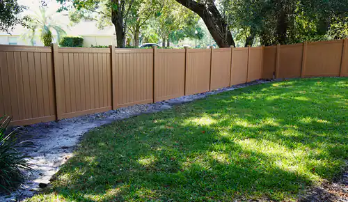 Cypress colored vinyl privacy fence running along a shaded rear property line in Lake Mary with fresh backfill at the base